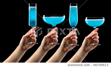 Set of hands holding glass of blue sparkling Set of hands holding glass of blue sparkling 66709813