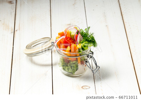 Fresh garden healthy vegetables in a glass jar Fresh garden healthy vegetables in a glass jar 66711011