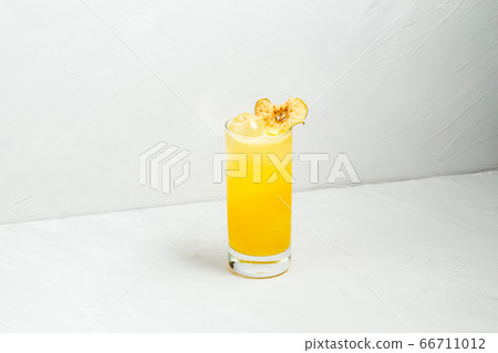 Fresh fruit yellow alcohol cocktail in a highball  66711012