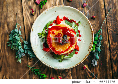 Sweet breakfast pancakes with berries and sauce Sweet breakfast pancakes with berries and sauce 66711176