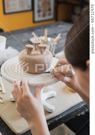Young woman attaching clay product part to future ceramic product. Pottery workshop. Young woman attaching clay product part to future ceramic product. Pottery workshop. 66712479