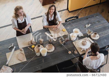Beautiful young female artist girls creating handmade pottery in modern art studio. Education kids and parents. Beautiful young female artist girls creating handmade pottery in modern art studio. Education kids and parents. 66712480