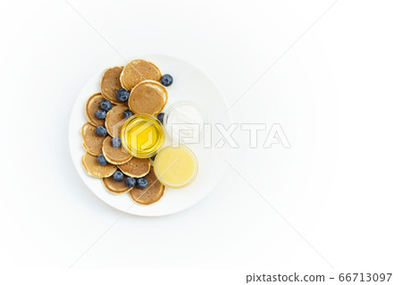 Pancake cereal with honey, yogurt and blueberry on white plate. Copy space right for text. Pancake cereal with honey, yogurt and blueberry on white plate. Copy space right for text. 66713097