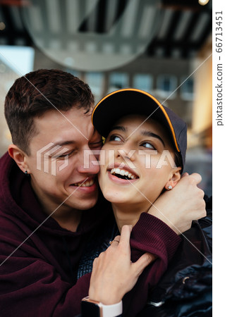 Guy and a girl are hugging at a table in a outdoor cafe. Guy and a girl are hugging at a table in a outdoor cafe. 66713451