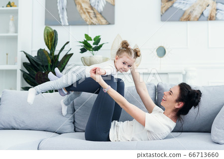 mom and her daughter lying on the couch in the living room. 66713660
