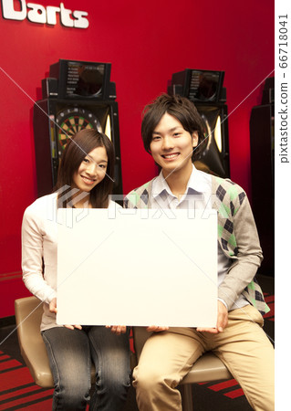 Couple with whiteboard in darts bar 66718041