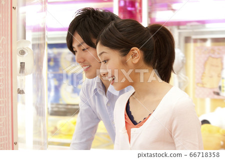 Couple playing crane games 66718358