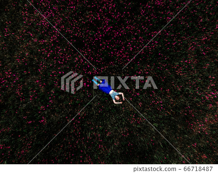 Woman lying on green grass in park Woman lying on green grass in park 66718487