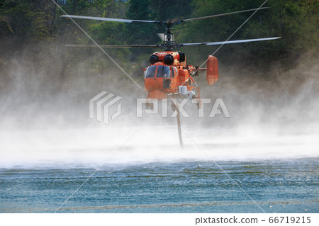 Firefighting helicopter is hovering over the pond Firefighting helicopter is hovering over the pond 66719215