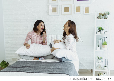 Two young women dance laughing together happy 66724037