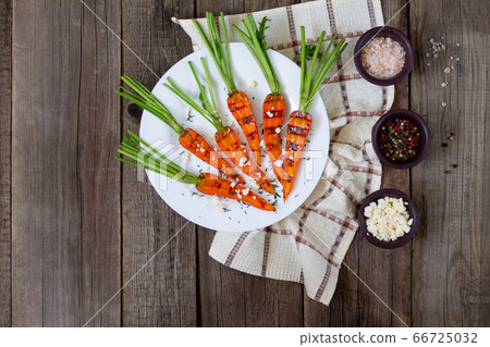 Farm organic grilled carrot with feta, pink salt and spice on rustic table top view Farm organic grilled carrot with feta, pink salt and spice on rustic table top view 66725032
