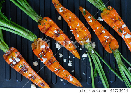 Baked or grilled carrots on the grill on wooden table top view Baked or grilled carrots on the grill on wooden table top view 66725034