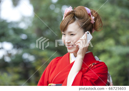 A woman in kimono making a phone call A woman in kimono making a phone call 66725603