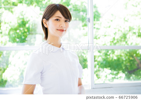 A smiling nurse in a white coat A smiling nurse in a white coat 66725906