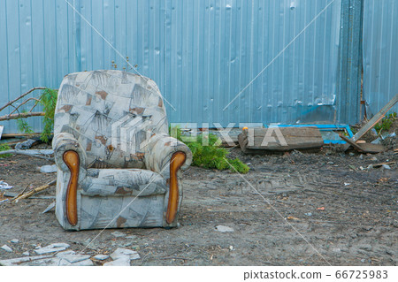 an old ragged chair in the trash. garbage collapse. furniture renovation 66725983