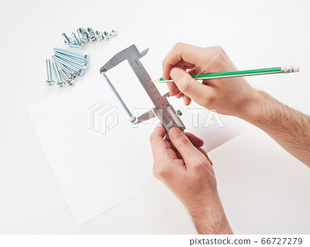 hands with a caliper measure bolts and nuts. hands with a caliper measure bolts and nuts. 66727279