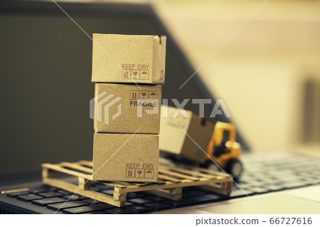 Fork-lift truck moves a pallet with box carton. Boxes brown color on laptop keyboard. Concept logistics, supply chain and delivery service depicts wide spread of products around globe in ecommerce 66727616