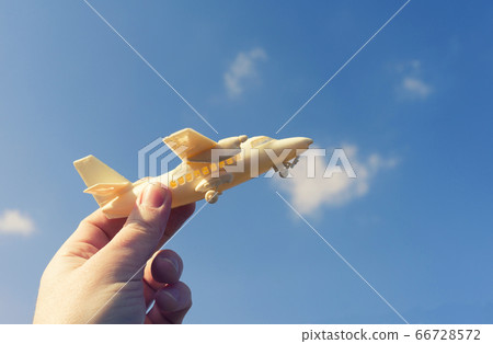close up photo of male hand holding toy airplane 66728572