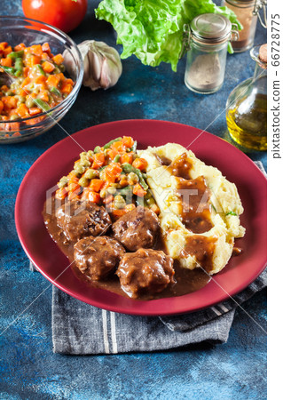 Roasted meatballs in dark sauce with mashed Roasted meatballs in dark sauce with mashed 66728775