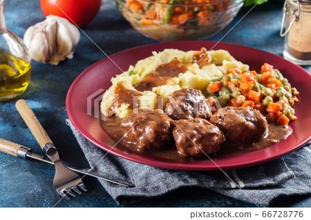 Roasted meatballs in dark sauce with mashed Roasted meatballs in dark sauce with mashed 66728776