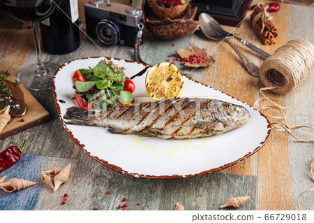 Grilled trout fish with salad and lemon Grilled trout fish with salad and lemon 66729018