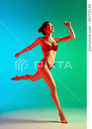 Fashion portrait of seductive girl in stylish swimwear posing on a bright gradient background. Summertime, beach season 66729149