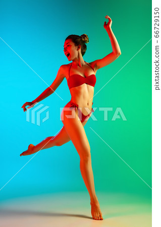 Fashion portrait of seductive girl in stylish swimwear posing on a bright gradient background. Summertime, beach season 66729150