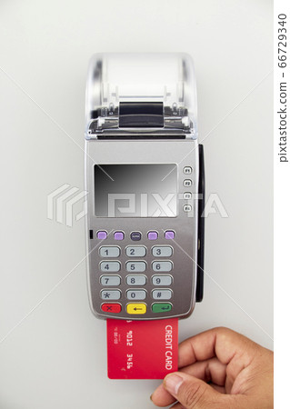 Men's hand is holding red credit card to terminal Men's hand is holding red credit card to terminal 66729340