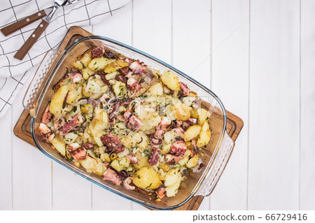 Baked octopus with potato and olives on white table, top view Baked octopus with potato and olives on white table, top view 66729416