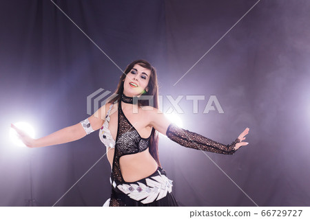 Young woman dancing in Tribal Fusion style. Belly dance on the stage. Young woman dancing in Tribal Fusion style. Belly dance on the stage. 66729727