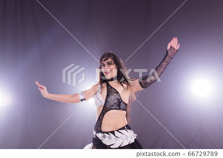 Young woman dancing in Tribal Fusion style. Belly dance on the stage. Young woman dancing in Tribal Fusion style. Belly dance on the stage. 66729789