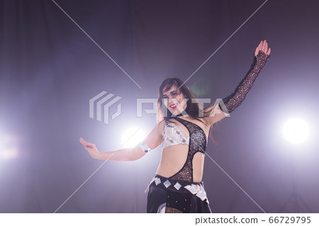 Belly dancer. Young attractive woman dancing tribal fusion on the stage. Oriental exotic dance. 66729795