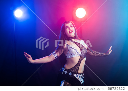 Young woman dancing in Tribal Fusion style. Belly dance on the stage. Young woman dancing in Tribal Fusion style. Belly dance on the stage. 66729822