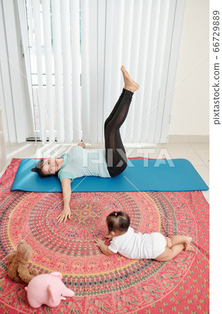 Young mother exercising at home 66729889