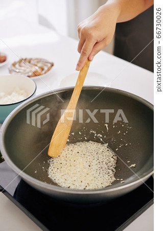 Woman frying diced onion 66730026