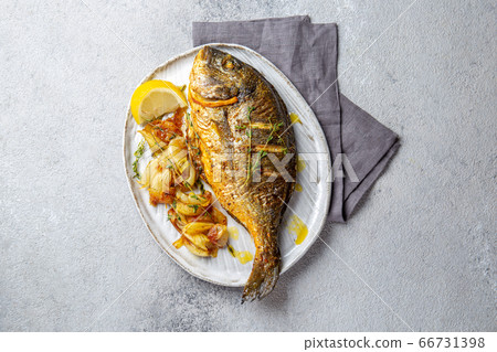 Grilled sea bream or dorada on gray plate. Gray background Grilled sea bream or dorada on gray plate. Gray background 66731398