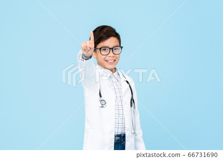 Little kid doctor smiling and pointing hand upward Little kid doctor smiling and pointing hand upward 66731690