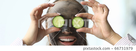 Girl with cosmetic mask on face cucumbers in eyes Girl with cosmetic mask on face cucumbers in eyes 66731979