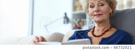 Elderly woman self-isolation reading book at home 66732021