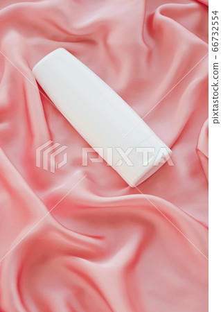 Blank label cosmetic container bottle as product mockup on pink silk background Blank label cosmetic container bottle as product mockup on pink silk background 66732554