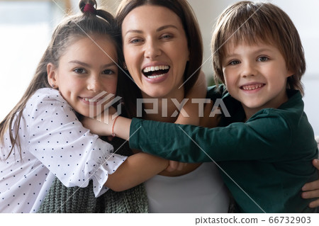 Head shot portrait two children hugging excited beautiful mother 66732903