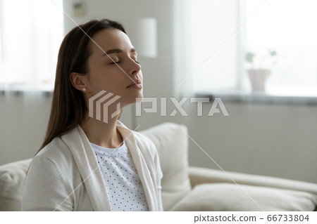 Calm woman resting closed eyes breathing fresh humidified air 66733804