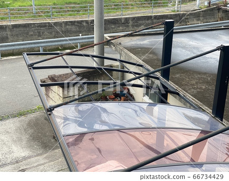 Carport with roof blown by strong wind 66734429