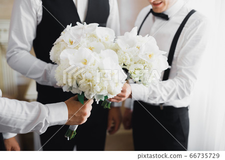 Beautiful man, groom holding big and beautiful wedding bouquet with flowers Beautiful man, groom holding big and beautiful wedding bouquet with flowers 66735729