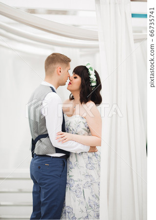 Gorgeous happy couple standing close to each other and looking in eyes 66735741