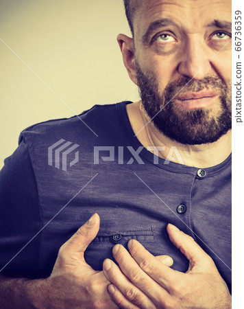 Man having heart pain attack Man having heart pain attack 66736359