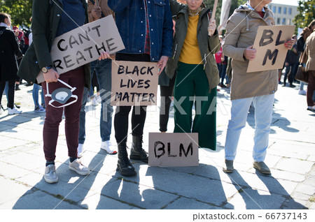 Unrecognizable black lives matters protesters holding signs and marching outdoors in streets. Unrecognizable black lives matters protesters holding signs and marching outdoors in streets. 66737143