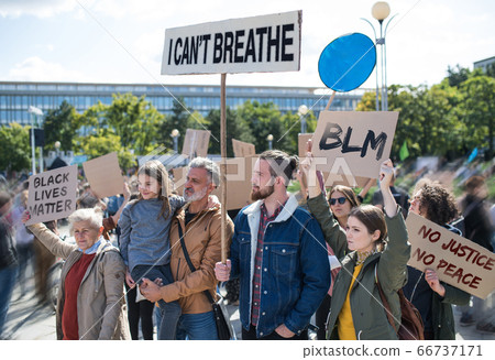 Black lives matters protesters holding signs and marching outdoors in streets. 66737171