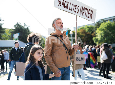 Black lives matters protesters holding signs and marching outdoors in streets. 66737173