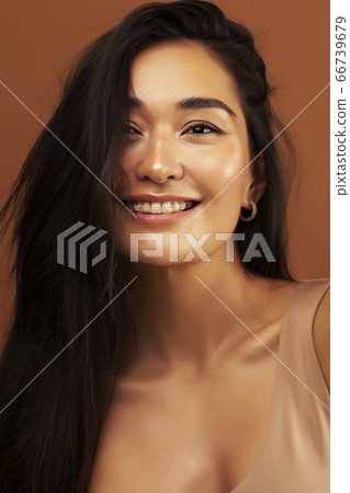 young pretty asian woman cheerful smiling posing on warm brown background, lifestyle people concept young pretty asian woman cheerful smiling posing on warm brown background, lifestyle people concept 66739679